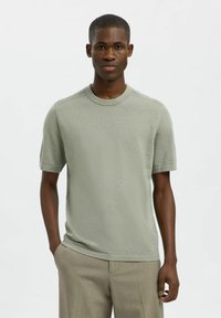 Vaaleanvihreä lyhythihainen pyöreäkauluksinen t-paita, joka on valmistettu teksturoidusta kankaasta, ja siinä on rento malli sekä huomaamattomat ompeluseokset.