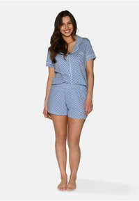 Kortärmad blå pyjamasset med vit geometrisk mönster, med knapp-up topp och matchande shorts, tillverkad av lätt tyg.
