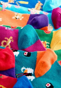 Krāsainas zeķes ar dažādiem rakstiem, tostarp dzīvniekiem un priekšmetiem, ar ribotu tekstūru un kontrastējošu pirkstu krāsu spilgtās toņos.