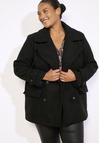 Schwarzer Peacoat aus Wollmischung mit großen Revers, doppelreihigen Knöpfen, zwei Fronttaschen und einer lockeren Passform. Glatte Textur, modernes Design.