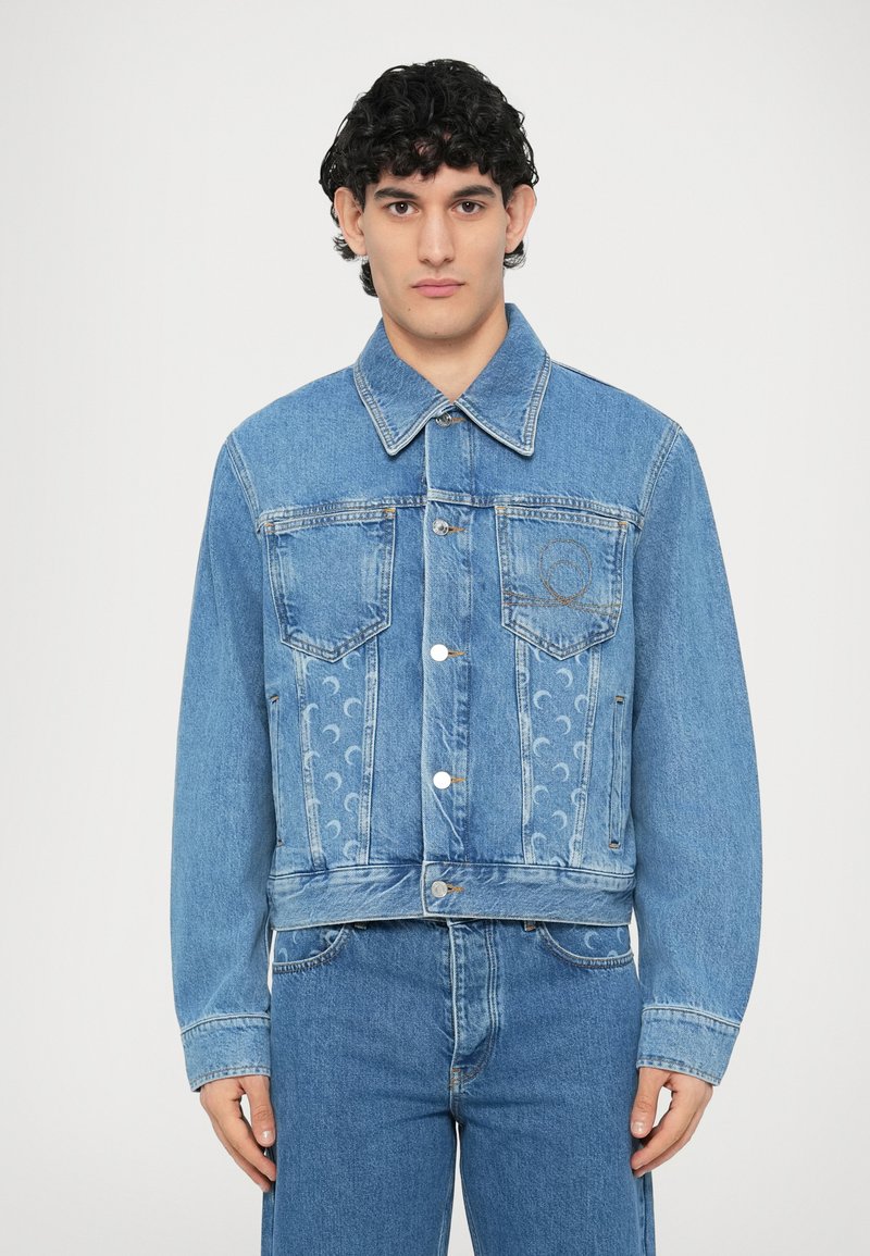 Τζιν μπουφάν σε ανοιχτό μπλε χρώμα με κοντό σχέδιο, δύο μπροστινές τσέπες και κεντημένο λογότυπο. Διαθέτει υφή στο πλευρό.