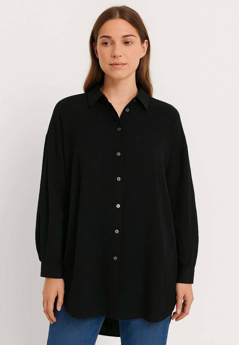 Black button-up shirt made of textured fabric, featuring a collar, long sleeves, and a rounded hem. Front buttons are silver-toned.