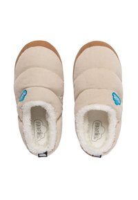 Zapatillas de casa de pana beige con forro blanco de felpa y suelas de goma marrón. Presenta un detalle del logo azul en la parte superior. Diseño de punta redondeada.