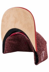 Red and brown patterned cap with a felt brim. Interior features black lining and adjustable strap. Embroidered logo on side.