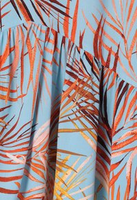 Tissu à imprimé floral avec de grands motifs de feuilles orange et marron sur un fond bleu clair, avec une finition légèrement texturée et un design froncé.