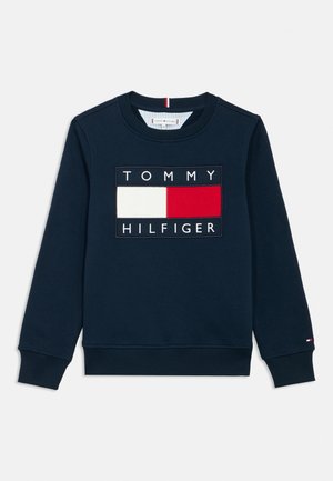 Džemper tamnoplave boje s okruglim izrezom, rebrastim manžetama i rubom, s pravokutnom Tommy Hilfiger oznakom u bijeloj, crvenoj i crnoj boji na prsima.