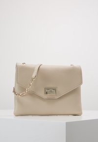Beige nahkakäsilaukku, jossa on teksturoitu pinta, läppäkiinnitys, kultaiset yksityiskohdat ja ketjuolkahihna. Kompakti suorakulmainen muoto.