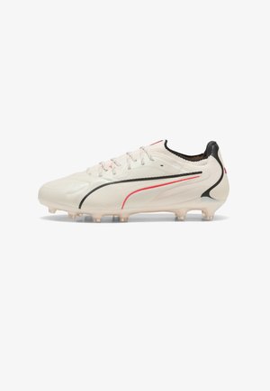 White soccer cleat with black and red curved stripes, low-cut design, and molded studs on the sole for traction on grass fields.