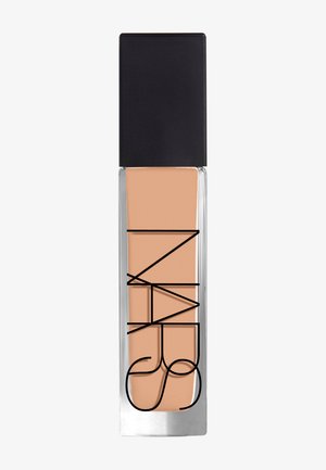 Flacon en verre rectangulaire avec bouchon noir contenant un fond de teint liquide beige avec le logo NARS en noir sur le devant.