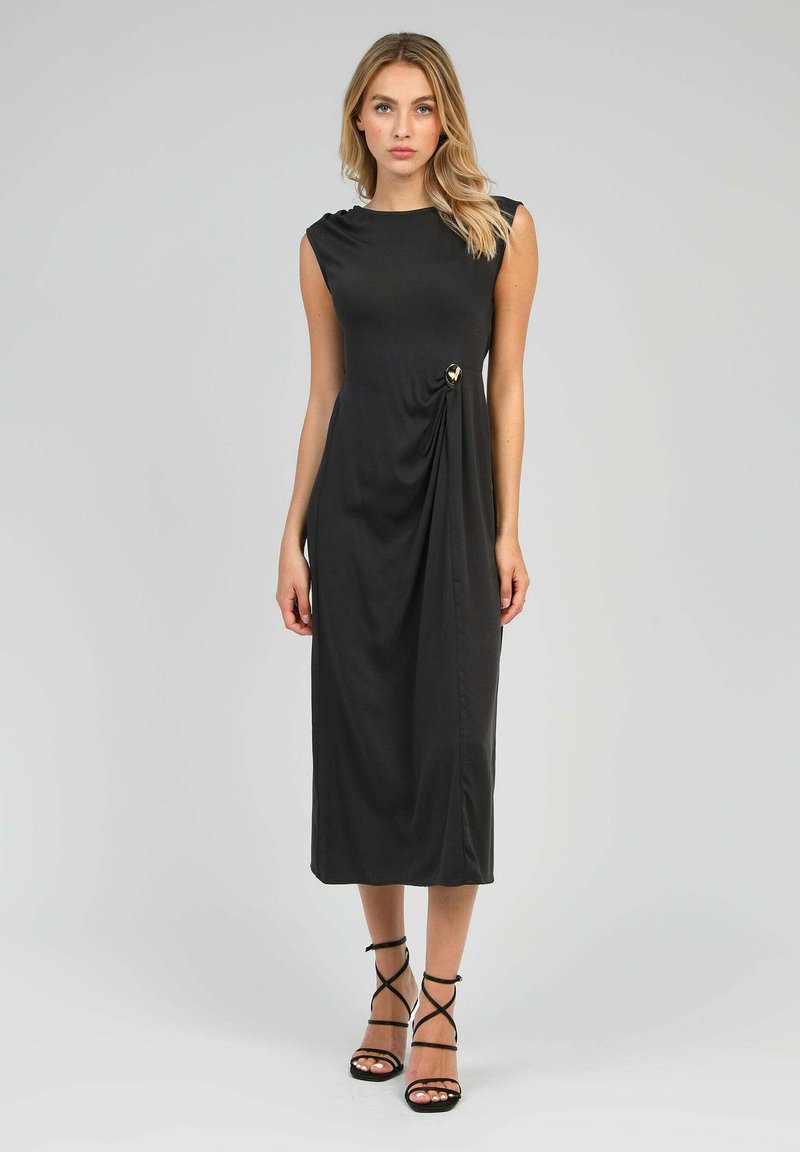 Robe midi noire avec un col rond, sans manches, détail de tissu drapé sur le côté et accent doré près de la taille.