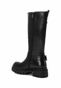 Botas de cuero negro hasta la rodilla con cremallera lateral, suela de goma gruesa y un detalle de correa ajustable alrededor del tobillo.