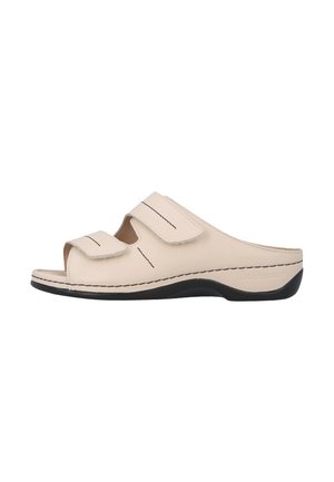 Beige åben tå slip-on sandal med to justerbare velcrolukninger og en sort sål, designet til komfort og nem påtagning.