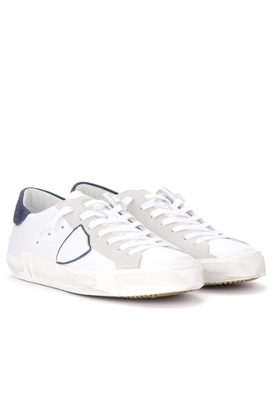 Witte leren sneakers met grijze suede accenten, ronde neus, witte veters en rubberen zool. Heeft minimale perforaties en een marineblauwe hieltab.