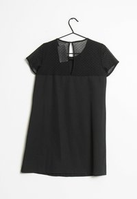 Robe noire avec un corsage ajusté et une jupe évasée. Le haut a des manches courtes et un tissu transparent à pois avec un détail dos en découpe. Texture lisse.