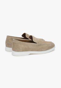 Beige suede slip-on shoes with a rounded toe, stitched detailing, and a white rubber sole. Soft texture with no visible hardware.