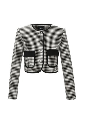 Veste cropped en motif vichy noir et blanc, avec un col rond, trois boutons et deux poches avant avec un biais noir.
