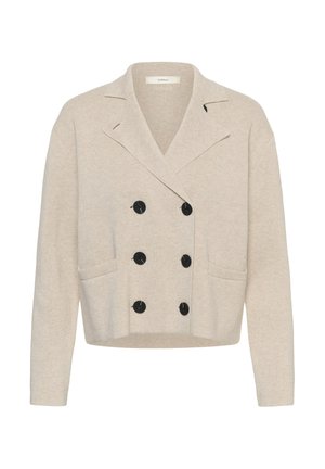 Cardigan beige à double boutonnage avec six boutons noirs, larges revers, deux poches avant, et manches longues, en tissu tricoté.