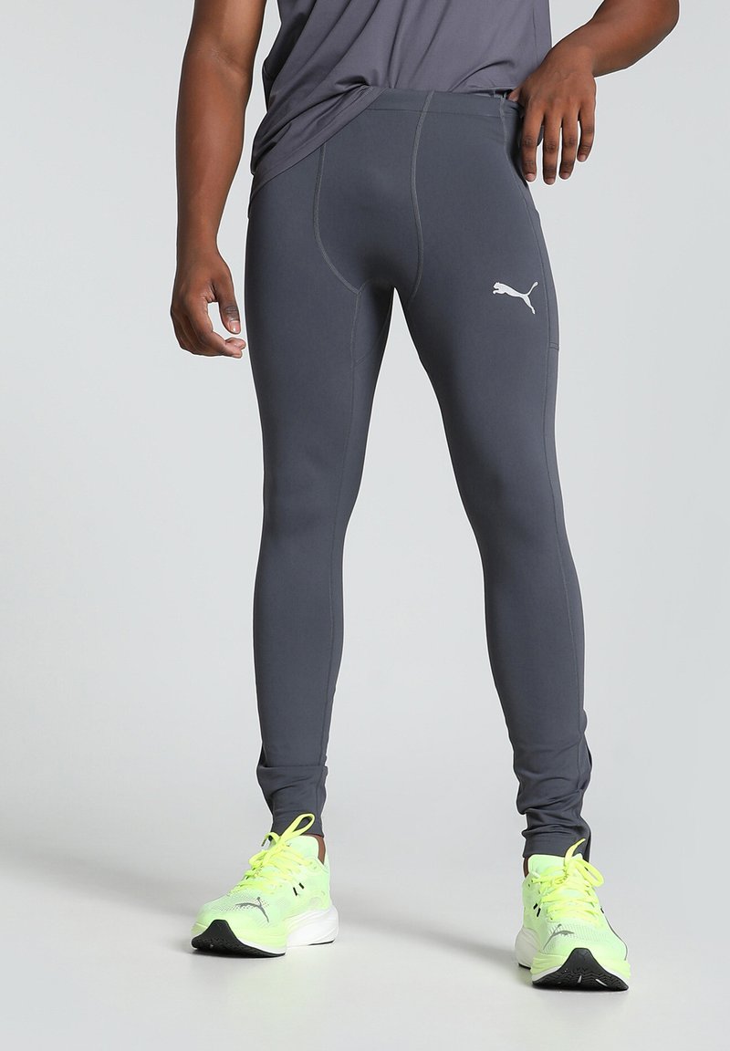 Hallid spordleggingsid, mis on valmistatud venivast kangast, kitsas lõikes, nähtavate õmblustega ja valge logoga vasakul reies.