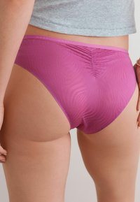 Roze naadloze onderbroek met een subtiel zebrapatroon en een hoge beenuitsnijding. Gemaakt van zachte, rekbare stof voor comfort.