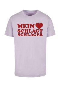 Lilla bomulds T-shirt med fed rød tekst, der står "MEIN ♥ SCHLAGT SCHLAGER." Korte ærmer og rund halsudskæring.
