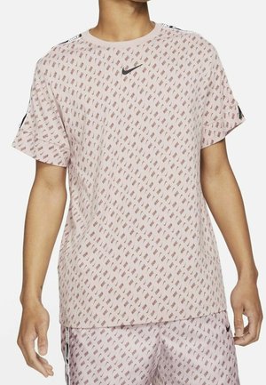 Light pink short-sleeve Nike t-shirt with repeating logo pattern, round neckline, and black accents on shoulders. Smooth texture.