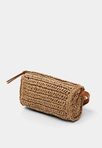 Wykonana z plecionego, jasnobrązowego słomkowego materiały torba o cylindrycznym kształcie, z zamknięciem na zamek błyskawiczny na górze oraz brązowym skórzanym uchwytem ułatwiającym noszenie.