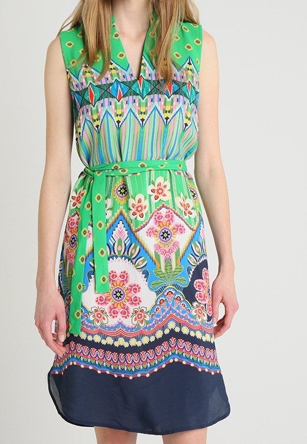 Robe à manches courtes avec un haut vert, un col à motifs, un buste à motifs et un ourlet contrastant bleu marine. Motifs floraux et détail de ceinture.