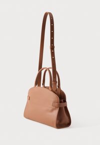 Gladbruine leren handtas met een afgeronde bovenkant, twee handvatten en een verstelbare schouderriem tegen een effen witte achtergrond.