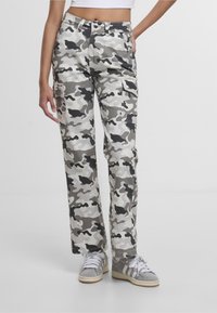 Pantalones cargo de camuflaje en tonos de gris, con un corte holgado, múltiples bolsillos y una tela de mezcla de algodón texturizada.