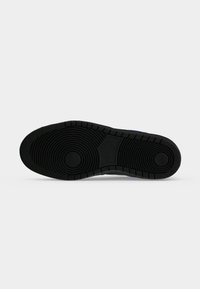 Μαύρη λαστιχένια εξωτερική σόλα ενός sneaker Nike SB με κυκλικά σχέδια στο πέλμα και το λογότυπο Nike SB στο κέντρο.