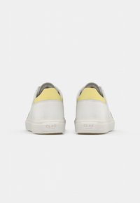 Sneaker bianche con accenti grigi e gialli, tomaia in pelle liscia, punta arrotondata e suola in gomma. Marchio CLAE sul tallone.