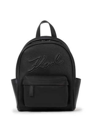 Sac à dos en cuir noir au fini texturé, avec un haut incurvé proéminent, une poche avant et un logo en relief.