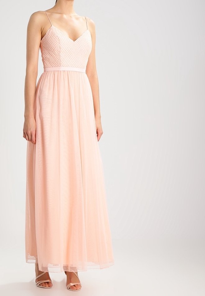 Longue robe de soirée rose pâle avec un corsage ajusté et texturé et une jupe fluide. Présente des bretelles fines et une taille marquée.