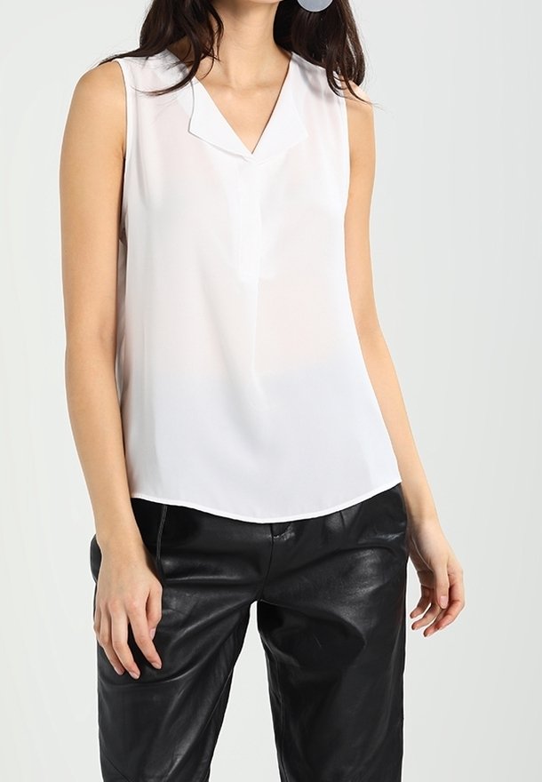 Mouwloze witte blouse met een v-hals, van lichte stof en met een gladde textuur, gecombineerd met zwarte leren broek.