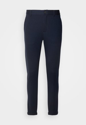 Navy blue pants made of soft fabric, featuring a button closure, belt loops, and rolled cuffs. Smooth texture with tailored design.