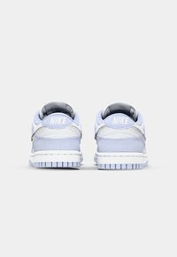 Nike-sneakers i ljusblått och grått, med vadderad krage, texturerad tyg och gummisulor med ett mönstrat mönster. Vit Nike-logotyp på hälarna.