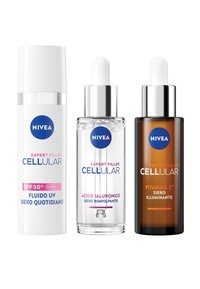 Tre prodotti per la cura della pelle NIVEA: una crema bianca SPF 50+, un siero chiaro di acido ialuronico in una bottiglia di vetro con pipetta e un siero ambrato scuro di vitamina C.