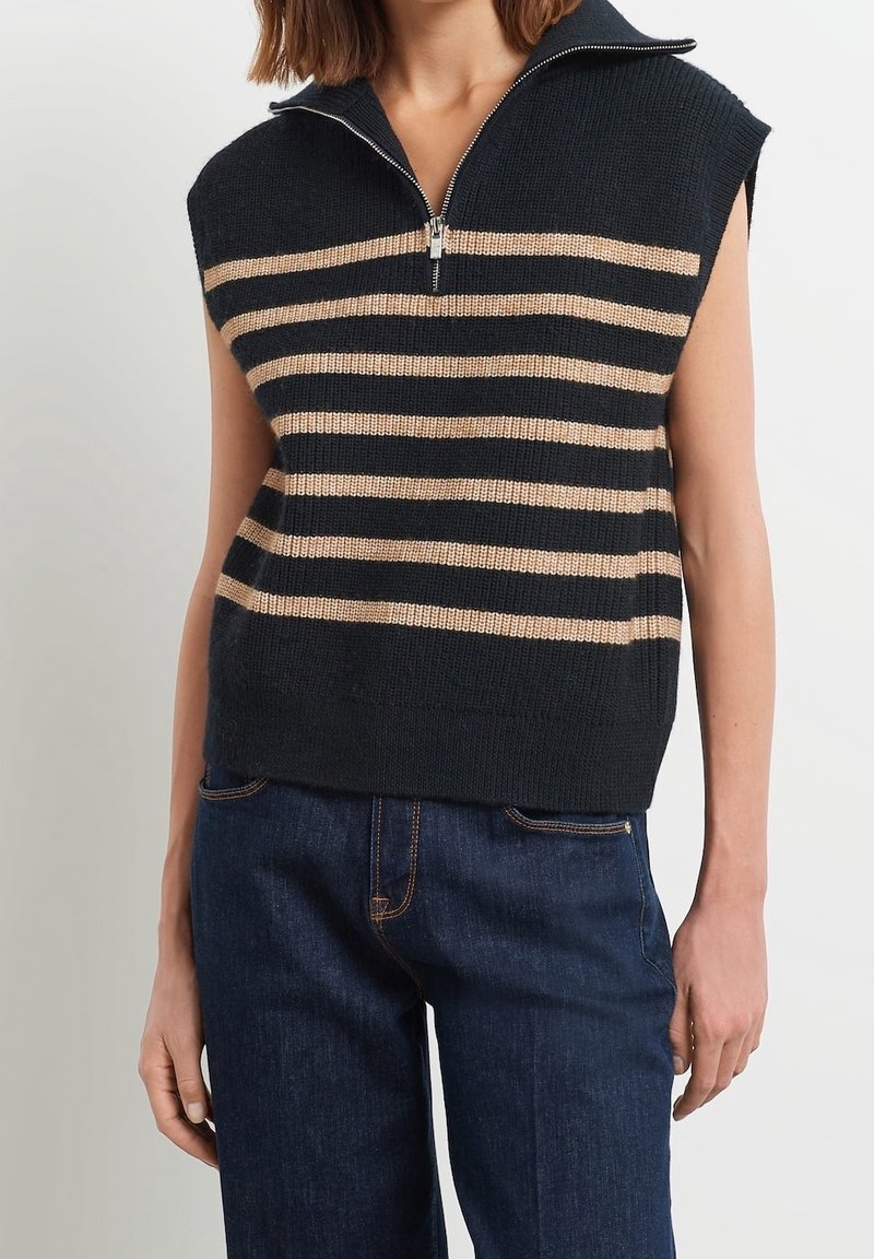 Marinblå ärmlös tröja med ljusbeige horisontella ränder, med hög krage och halv dragkedja. Stickad struktur med en lös passform.