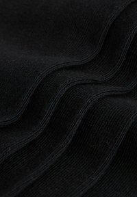 Sort tekstureret stof med bløde, ribbede bølger og subtil glans. Synlige stikninger tilføjer detalje og skaber et glat, lagdelt udseende.