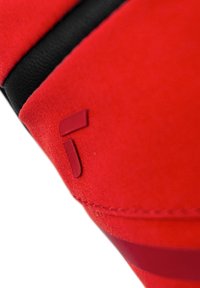 Sacca di tessuto rosso con accentuazioni nere, caratterizzata da una texture liscia e un logo a rilievo prominente in un rosso più scuro a contrasto.