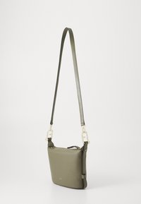 Borsa a spalla in pelle verde oliva con forma rettangolare, hardware dorato, tracolla regolabile e chiusura a zip. Texture liscia, design minimalista.