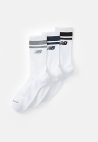 Juego de tres pares de calcetines deportivos blancos, con rayas horizontales en gris, marino y negro, y textura acanalada. Logo de New Balance en cada calcetín.