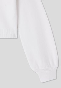 Biała rękawica swetra z ściągaczem i miękką tkaniną. Projekt jest prosty z minimalną ilością szwów.