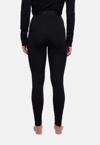 Leggings noirs en matériau doux et extensible. Dotés d'une taille sans couture et d'une coupe ajustée avec une texture lisse.