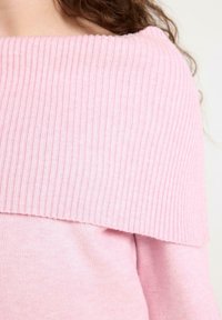Hellrosa gestrickter Pullover mit einem gerippten, schulterfreien Ausschnitt. Weiche Textur mit einem nahtlosen Übergang zu einem schlichten Körperdesign.