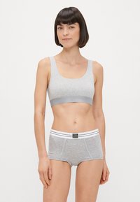 Γκρι μπραλέτ με βαμβακερό μείγμα και φαρδιές τιράντες, σε συνδυασμό με γκρι σορτς αγοριού που διαθέτουν λευκή ρίγα στη μέση και λογότυπο μπροστά.