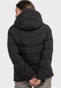 Schwarze Daunenjacke mit Kapuze, ausgestattet mit einem gesteppten Design und langen Ärmeln. Das Material ist glatt und leicht glänzend.