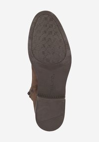Stivale alla caviglia in suede marrone con suola in gomma piatta. La suola presenta un motivo di grip testurizzato e lo stivale ha una chiusura con zip laterale.