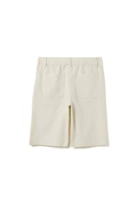 Pantalones cortos de lino color crema con cinturilla elástica, corte recto y dos bolsillos traseros. La tela tiene una textura suave y una sensación ligera.