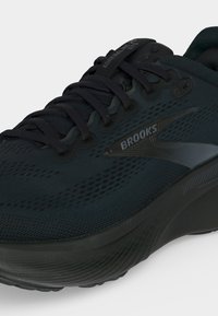 Close-up of black Brooks Adrenaline GTS running shoe with textured mesh upper and thick cushioned sole.